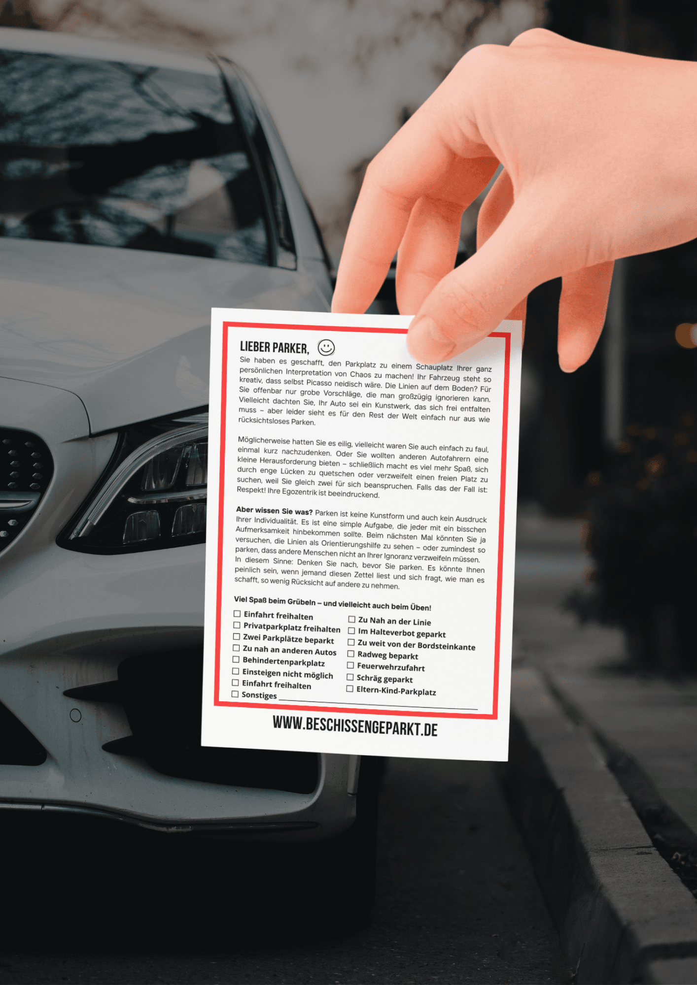 Falschparker-Notiz: Hand hält Hinweiskarte „Beschissen geparkt" im A5-Format vor ein falsch geparktes Auto